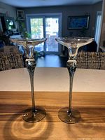 full view of both glass candleholders standing on table