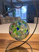 Front view of multicolour glass friendship ball on stand