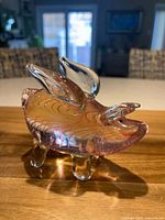 side view of clear glass pig with wings showing pink swirls