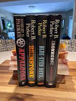 Front spines of all four hardcover novels