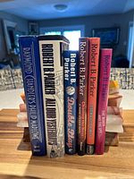 Front view of six hardcover books standing together