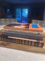 Stack of five hardcover reference books on countertop