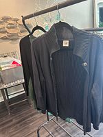 Front view of navy ribbed cardigan on hanger, green-back top partially visible