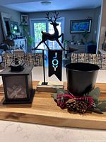 Group view of three black holiday decor items on wooden surface