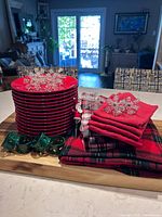 Stack of red plates, napkin rings, folded napkins, Santa stopper displayed