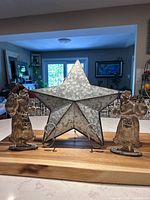 Front view of two silver Santas and galvanized star