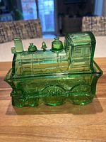 front and side view of green glass locomotive covered dish showing overall form
