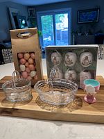 All items arranged: two glass baskets, boxed porcelain eggs, bag of plastic eggs, bunny egg cup