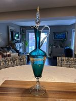 Full view of teal Empoli decanter with stopper showing overall form