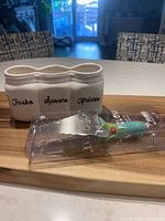 Cake server in original packaging beside ceramic utensil caddy