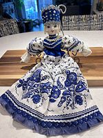 Full view of blue and white folklore doll standing on counter