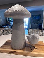 Mushroom and bird ornaments side by side on tabletop