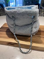 Front of icy blue plush handbag with chain strap
