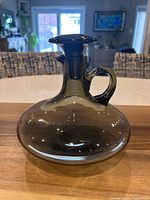 Full view of decanter with stopper, smoky taupe glass, handle visible
