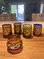 Five glass pieces: four coloured gilt-enamel tumblers and one bud vase