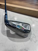 Back of Cobra Amp Cell 7-iron head showing branding and cavity design