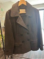 Front view of double-breasted wool peacoat on hanger