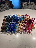 Full grouping of multi-coloured plastic hangers spread on countertop