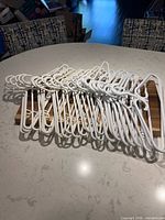 Stack of 29 white plastic hangers on tabletop