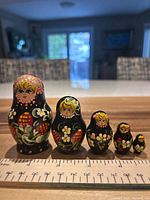 Front view of all five nesting dolls with ruler for scale