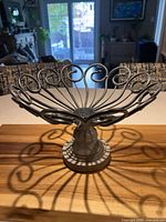 angled view showing metal scrollwork bowl and full pedestal