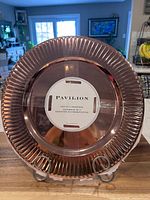 Front view of copper charger plate with Pavilion label