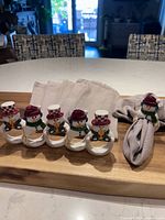 Full set of ceramic snowman napkin rings and grey napkins on board