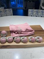 Full set of pink napkins folded with eight hydrangea napkin rings displayed on board