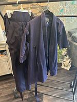Full view of jacket and pants on hangers