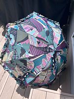 Top view of umbrella open showing multicolour geometric canopy and ruffled edge