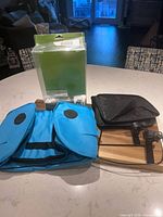 Blue bag folded, black bag folded, mounting brackets and boxed packaging on counter