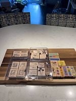 Overview of four boxed stamp sets and additional loose sentiment stamps on cutting board