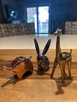 Three Umbra animal ring holders lined up on wood surface