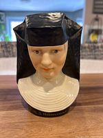 Front view of porcelain nun bust showing facial details and habit