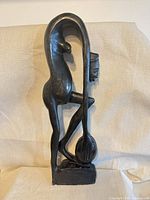front angled view of carved wood abstract sculpture on base