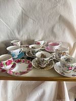 Front view of all nine teacups and saucers on tray