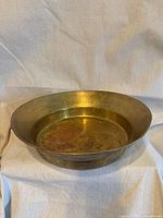 Side view of brass basin showing overall form and patina