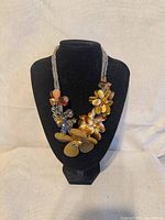 Front view showing entire floral statement necklace on display bust
