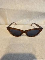Front view showing cat-eye shape, tortoise frame, dark lenses