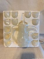 Full set in styrofoam showing pot centered, twelve cups around