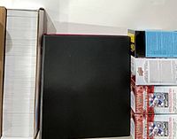 Long white card storage box filled with cards, black binder and stacked retail Upper Deck boxes