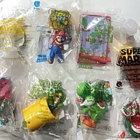 Six sealed Super Mario Happy Meal toys laid out