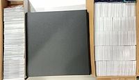 Top-down view of two card storage boxes and closed black binder