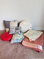 Group shot of wool blankets and five decorative pillows