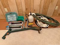 Full lot overview including hoses, sprayer, sprinklers, kneeler, tool shaft and accessories