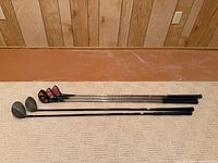 Five clubs laid out full length on floor