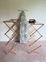 Laundry items group shot: two wooden drying racks, floral ironing board, Proctor Silex iron
