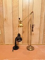 Brass floor lamp and black desk lamp together showing full view and bases