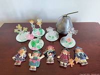 Full lot view: glass figurines, metal pear, resin dolls