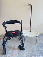 Rollator beside shower bench and cane